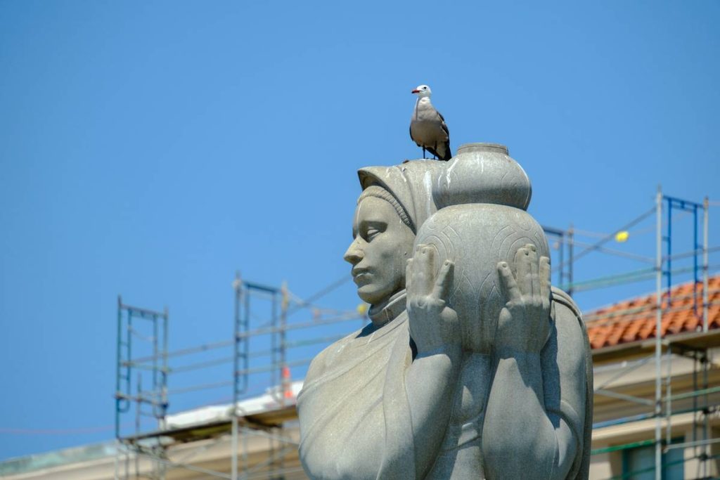 a bird is perched on top of a statue