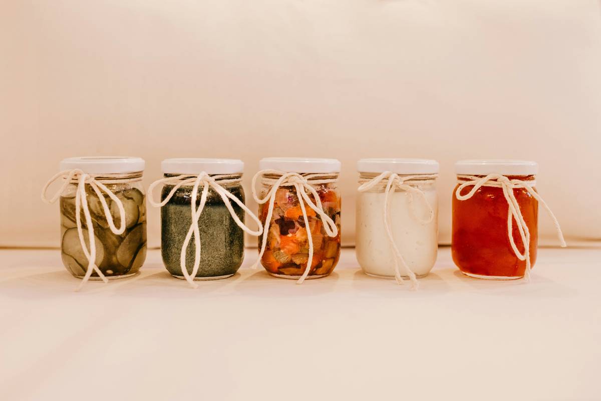 Side-by-side comparison of borosilicate vs soda-lime glass yogurt jars showing thermal stress cracks in inferior jar